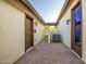 Clean side yard with paver stones, wrought iron gate, and access to the backyard at 15803 W Almeria Rd, Goodyear, AZ 85395