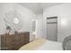 Bright bedroom featuring a dresser with floral mirror and an adjacent closet at 18356 W Gray Fox Trl, Wittmann, AZ 85361