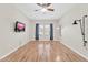 Well-lit bedroom featuring wood-look floors, a ceiling fan, and dark curtains at 20121 N 76Th St # 2021, Scottsdale, AZ 85255