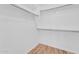 Walk-in closet with wood-look floors and simple shelving system for optimal organization at 20121 N 76Th St # 2021, Scottsdale, AZ 85255