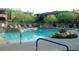Inviting community pool with lush landscaping, rock features, and ample seating at 20121 N 76Th St # 2021, Scottsdale, AZ 85255