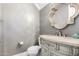 Elegant half bathroom with a marble countertop, decorative mirror, and gray painted walls at 20576 W Briarwood Dr, Buckeye, AZ 85396
