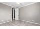Neutral bedroom with gray walls, light hardwood floors, ceiling fan, and an open door to walk-in closet at 20576 W Briarwood Dr, Buckeye, AZ 85396