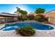 Backyard oasis with a beautiful pool surrounded by lush greenery and decorative brick paving at 20576 W Briarwood Dr, Buckeye, AZ 85396