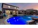 Backyard view of the pool with blue lighting, covered patio, and outdoor seating, perfect for entertaining and relaxing at 20576 W Briarwood Dr, Buckeye, AZ 85396