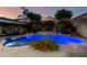 Inviting pool with vibrant flowers, lush landscaping, and a covered patio for relaxing in this backyard oasis at 20576 W Briarwood Dr, Buckeye, AZ 85396