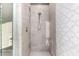 Modern shower features neutral tile, geometric floor, built-in niche, and updated fixtures at 20576 W Briarwood Dr, Buckeye, AZ 85396