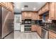 Well-lit kitchen with wooden cabinetry, stainless steel appliances, and black granite countertops at 2110 W Morrow Dr, Phoenix, AZ 85027