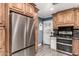 Updated kitchen with stainless steel refrigerator and range with wooden cabinets and tiled flooring at 2110 W Morrow Dr, Phoenix, AZ 85027