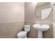 Powder room features a pedestal sink, tiled walls, and decorative mirror at 2116 W Fawn Dr, Phoenix, AZ 85041