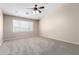 Large bedroom features a ceiling fan, neutral carpet, and a large window at 2116 W Fawn Dr, Phoenix, AZ 85041