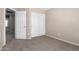 Bedroom boasts neutral carpet and paint, two closets and one additional door at 2116 W Fawn Dr, Phoenix, AZ 85041