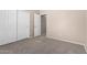 Bedroom boasts neutral carpet and paint, two closets and one additional door at 2116 W Fawn Dr, Phoenix, AZ 85041