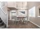 A virtual staged dining room with a round table, four chairs, tile floors, a large window, and a modern chandelier at 2116 W Fawn Dr, Phoenix, AZ 85041
