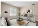 A virtual staged living room with neutral tones, two sofas, a rounded coffee table, a lamp, and bright natural light at 2116 W Fawn Dr, Phoenix, AZ 85041