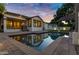 Inviting backyard with a swimming pool reflecting the home's exterior and string lights at dusk at 2774 E Valencia St, Gilbert, AZ 85296