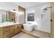 Modern bathroom featuring a soaking tub, white marble tile, and wood vanity at 2774 E Valencia St, Gilbert, AZ 85296