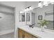 Modern bathroom with dual vanity sinks, updated lighting, and a tiled walk-in shower at 2774 E Valencia St, Gilbert, AZ 85296