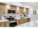 Modern kitchen features stainless steel appliances, light wood cabinetry, and white backsplash at 2774 E Valencia St, Gilbert, AZ 85296
