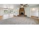 Spacious living room with a cozy brick fireplace, a ceiling fan, an open layout, and an adjacent room with lots of natural light at 2847 S Bala Dr, Tempe, AZ 85282