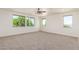 Spacious carpeted bedroom featuring large windows and a ceiling fan at 2920 E Virginia E St, Mesa, AZ 85213