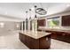 Modern kitchen with a large island, granite countertops, stainless steel appliances, and dark wood cabinetry at 2920 E Virginia E St, Mesa, AZ 85213
