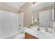Well-lit bathroom featuring a tiled shower-tub, modern faucet, white sink and a wood cabinet at 29368 N Red Finch Dr, San Tan Valley, AZ 85143
