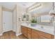 Bright bathroom featuring wood floors, double sinks, a large mirror, and modern lighting at 29368 N Red Finch Dr, San Tan Valley, AZ 85143