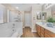 Clean bathroom features a shower with glass door, soaking tub, wood floors, and double sinks at 29368 N Red Finch Dr, San Tan Valley, AZ 85143