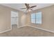 Bedroom features neutral carpet, ceiling fan with lighting, window, and open walk-in closet at 29368 N Red Finch Dr, San Tan Valley, AZ 85143