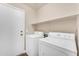 Clean laundry room with washer and dryer and white walls and shelves with tan trim at 29368 N Red Finch Dr, San Tan Valley, AZ 85143