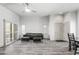 Light-filled living room boasts a modern couch, hardwood floors, and views of outdoor shutters at 295 N Rural Rd # 133, Chandler, AZ 85226