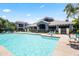 Community pool with lounge chairs and a clubhouse on a sunny day at 295 N Rural Rd # 133, Chandler, AZ 85226