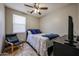 Cozy bedroom with a ceiling fan, a single bed, and a dark wood dresser under a flat screen TV at 3088 E Andre Ave, Gilbert, AZ 85298
