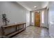 Bright foyer featuring tile flooring, a wooden console table, and sidelight windows flanking the entry door at 3088 E Andre Ave, Gilbert, AZ 85298