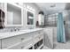 Elegant bathroom featuring a dual sink vanity, marble accents, and a modern glass-block shower at 3102 W Betty Elyse Ln, Phoenix, AZ 85053