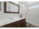 Bright bathroom featuring a single sink vanity, framed mirror and walk-in shower with tiled surround at 3114 E Kristal Way, Phoenix, AZ 85050