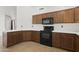 Kitchen featuring wood cabinets, and black appliances complemented by sleek countertops at 3114 E Kristal Way, Phoenix, AZ 85050