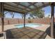 Backyard view of the pool, patio, and block fence, set against a bright blue sky at 3114 E Kristal Way, Phoenix, AZ 85050