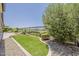 Backyard featuring an olive tree, rocks, artificial grass, and a view of the golf course at 36172 N Secret Garden Path, Queen Creek, AZ 85140