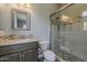 Bathroom featuring a glass shower, tile accents, sink with gray cabinets, and a gray tiled floor at 36172 N Secret Garden Path, Queen Creek, AZ 85140