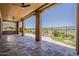 Spacious covered patio with stone flooring, built-in grill, ceiling fans and a stunning view of the lush landscaping and golf course at 36172 N Secret Garden Path, Queen Creek, AZ 85140