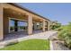 Large covered patio area with sliding glass doors, ceiling fans, and views of the carefully designed backyard and community at 36172 N Secret Garden Path, Queen Creek, AZ 85140