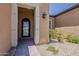 Close-up of the home's entrance, featuring a decorative iron door, manicured landscaping, and paver walkway leading to the front door at 36172 N Secret Garden Path, Queen Creek, AZ 85140