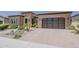 Front exterior of home with three-car garage, stucco, and desert landscaping at 36172 N Secret Garden Path, Queen Creek, AZ 85140
