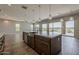 Large kitchen island and a view of the adjacent Gathering room with walls of windows looking out to the water at 36172 N Secret Garden Path, Queen Creek, AZ 85140
