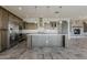 Well-equipped kitchen with a central island, stainless steel appliances, and adjacent living area with fireplace at 36172 N Secret Garden Path, Queen Creek, AZ 85140