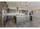 Modern kitchen with stainless appliances, light countertops, and a center island overlooking the living area at 36172 N Secret Garden Path, Queen Creek, AZ 85140