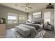 Serene bedroom featuring neutral decor, a ceiling fan, and views to the outside at 36172 N Secret Garden Path, Queen Creek, AZ 85140