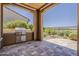 Outdoor kitchen area featuring a tile floor and built in grill overlooking the golf course at 36172 N Secret Garden Path, Queen Creek, AZ 85140